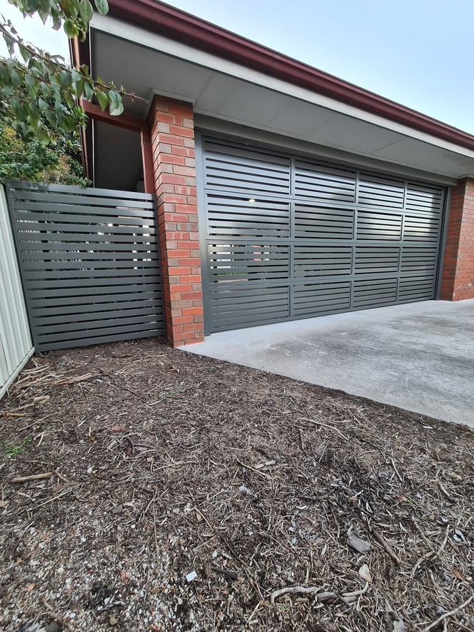 Grey slat sliding gate on a residential driveway