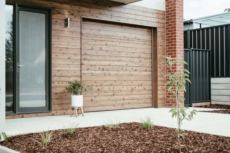 Timber and brick home with a light sectional garage door