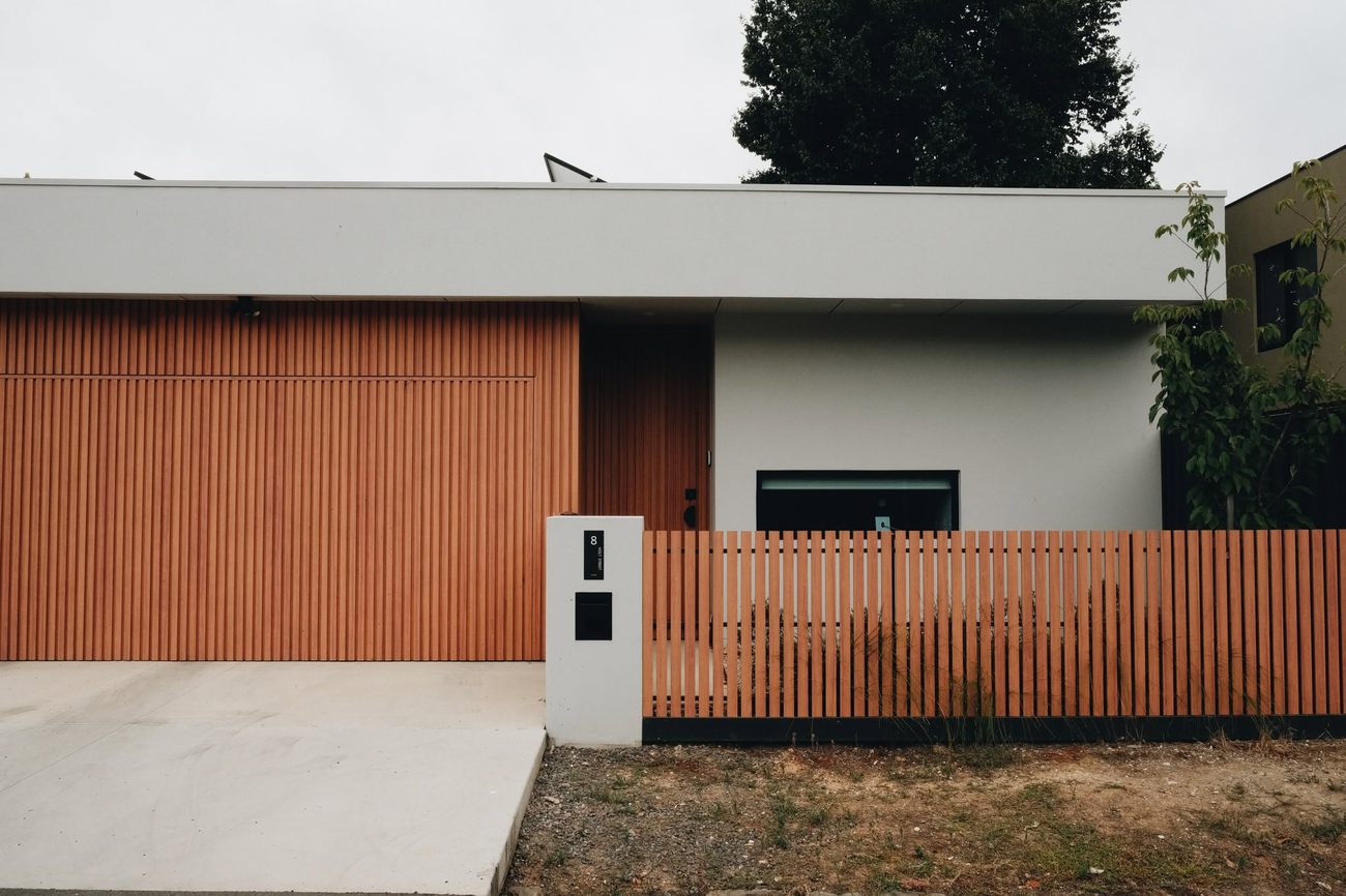 Timber look clad garage door with matching slat fence